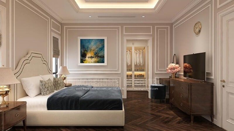 Sắp xếp nội thất phòng ngủ tân cổ điển nhẹ nhàng, sang trọng với giường bọc nệm trắng, kệ tivi gỗ óc chó cao cấp.